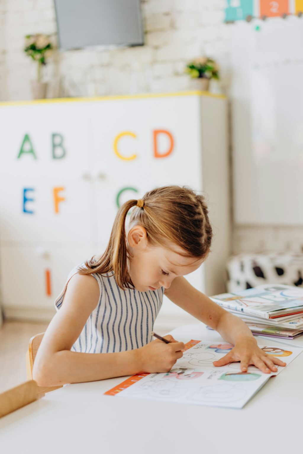 A young girl focused on coloring a book in a primary classroom setting, enhancing learning.